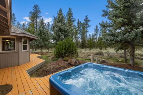Soak in your private hot tub surrounded by towering pines and endless forest views on this peaceful deck.
