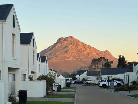 Twilight estate street view with dramatic mountain glowing amber at sunset - the backdrop you'll wake up to every morning