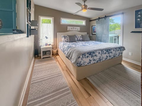 Bright king bedroom with natural light, barn door, and calming coastal style