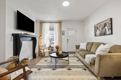 Cozy and stylish living room featuring a comfortable sofa and a large 55" Roku Smart TV mounted above a modern fireplace. The perfect spot to relax and stream your favorites!
