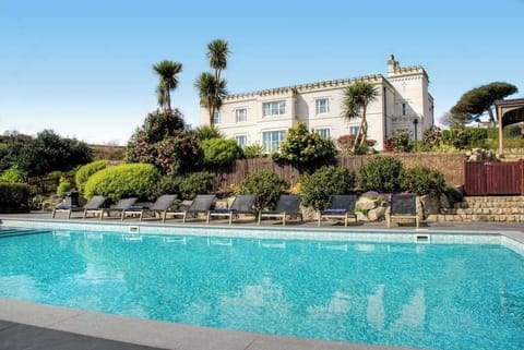 Elegant outdoor pool with sweeping coastal views across the estate grounds