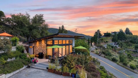The home glows at dusk, highlighting the unique roofline.