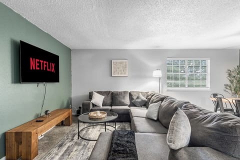 Spacious and inviting living area with comfortable seating and a smart TV, perfect for relaxing after exploring Arlington or attending events at AT&T Stadium.
