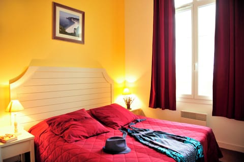 The upper-level double bedroom has warm tones and a double bed — space for two after a day on the coast