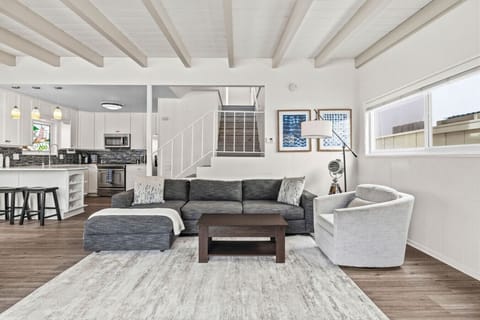 Bright open-concept living room with comfortable seating and seamless access to the kitchen.