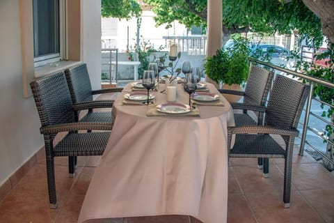 Outdoor dining beneath the trees creates an easy rhythm between the house, the courtyard, and the nearby sea.