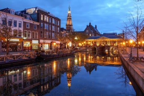 Stroll canalside at dusk, surrounded by glowing city lights.