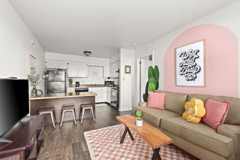 Open studio layout featuring a kitchen island, cozy seating, and cheerful artwork.