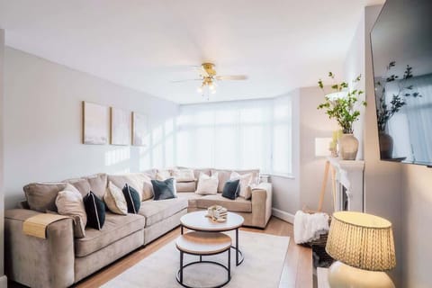 Spacious lounge featuring soft sofa, neutral tones, and natural light.
