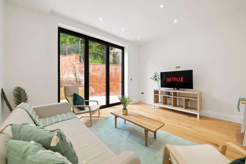 Bright modern living room with TV, garden doors, cozy seating