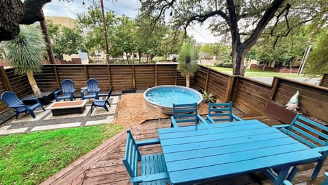 Private fenced backyard with plunge pool, fire pit, and shaded outdoor dining