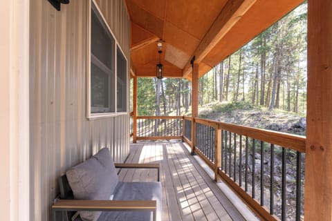 Relax on your private covered deck and soak in the peaceful forest views, where tall pines create a serene natural backdrop for your mountain getaway.