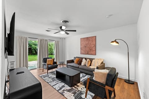 Bright, sun-filled living room with cozy seating and a smart TV—perfect for relaxing after an exciting FIFA match. Step out to the private backyard for fresh air between game days.