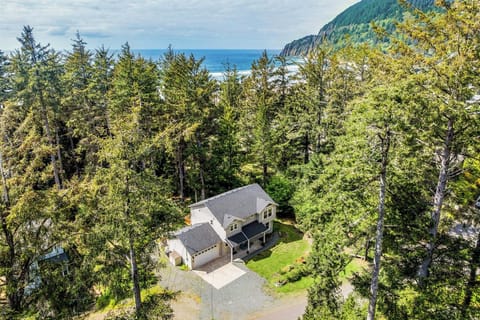 Charming coastal retreat nestled among evergreens with mountain and ocean views, offering peaceful privacy near the beach.