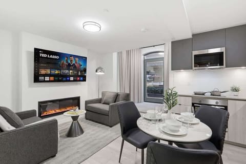 Open-concept living and dining area with Smart TV, fireplace, and modern kitchen