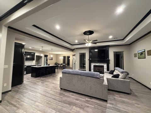 Spacious open living area with fireplace, chef’s kitchen, and modern finishes