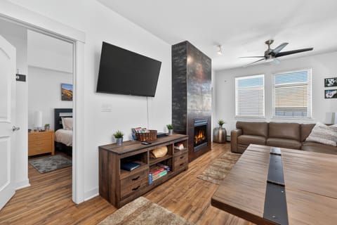 Sink into plush leather seating and feel the warmth of the fireplace glow across this bright, modern living space with vaulted ceilings and natural light.