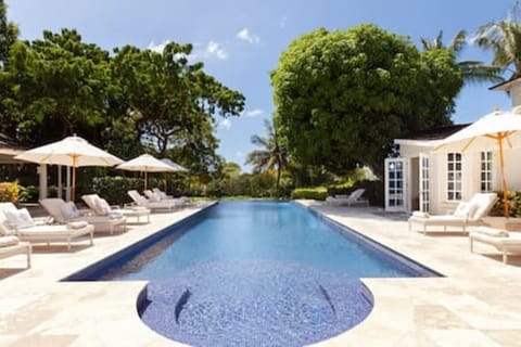Beautiful infinity swimming pool with inviting sun loungers and parasols
