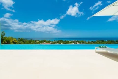 Beautiful private infinity pool with sun loungers, sun umbrellas, garden sofas and a fabulous sea view.