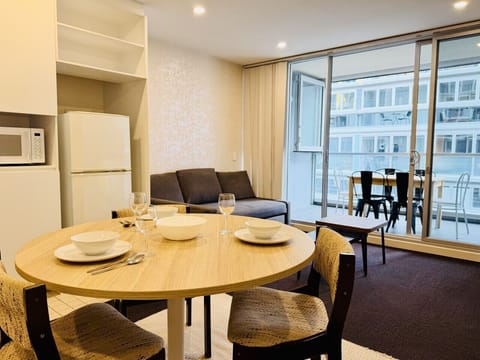 Bright open-plan living and dining area with balcony access — a comfortable base in the heart of Adelaide CBD.