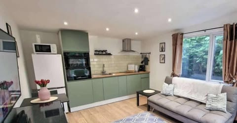 Bright open-plan living area with comfortable sofa bed and free parking included for your stay