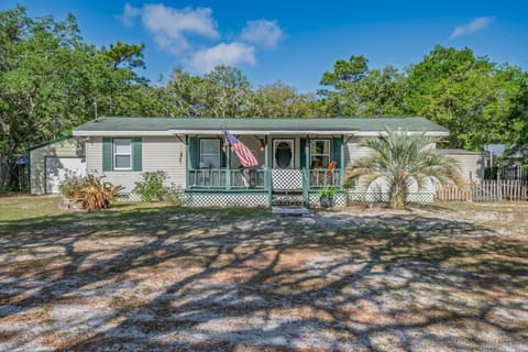 Front porch with rocking chairs and a welcoming flag — settle in and listen to the neighbourhood settle down around you