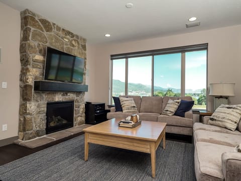 Main level living room with stone fireplace and large windows.