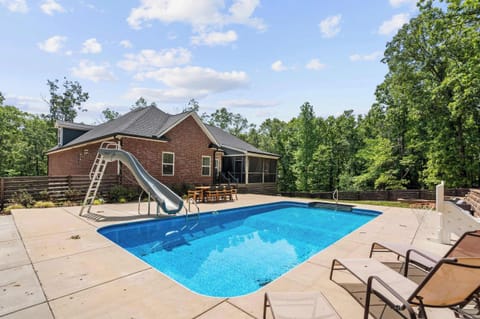 Outdoor fun awaits with a refreshing pool, exciting slide, bbq grill, outdoor dining space, lounge chairs, and a firepit—all for a perfect stay!
