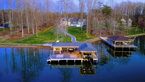 Backyard - The home sits up the slope from the waterfront, with the dock, sandy beach, and boathouse spread out below.