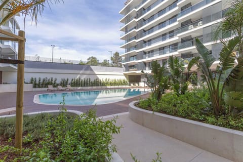 19 · Shared outdoor pool surrounded by tropical landscaping · StayInLisbon