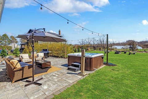 Paver patio with hot tub, gas grill, and farmland views