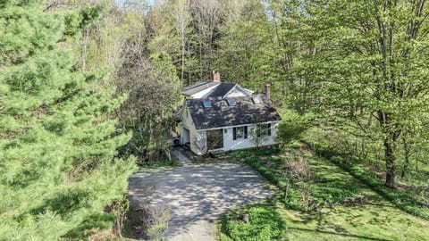 Aerial view showing the house, skylights, and private wooded setting