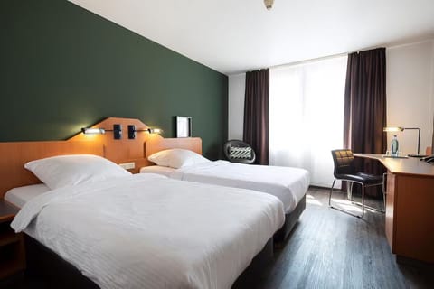Unwind in crisp twin beds with soothing, sunlit comfort.