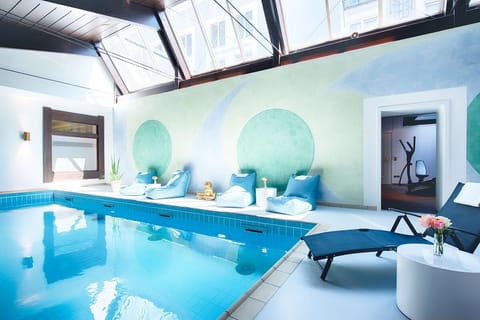 Linger poolside on plush loungers under airy skylights.
