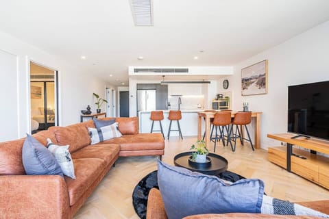 The open-plan layout brings the kitchen, dining, and living spaces together in a bright contemporary setting designed for easy connection and comfortable city stays.
