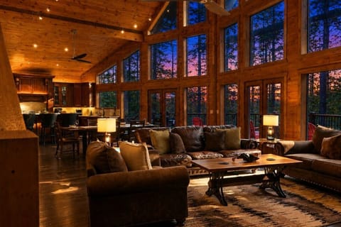 Spacious open-concept cabin with stunning forest views and cozy seating.