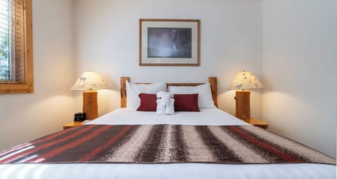 Unwind into crisp linens with warm lodge-style lighting.