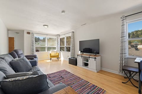 Bright and comfortable lounge with plush gray seating and large windows that fill the space with natural light