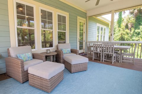 Unwind on a covered porch with cozy wicker seating and garden views—your perfect spot to sip morning coffee or relax after exploring nearby attractions.