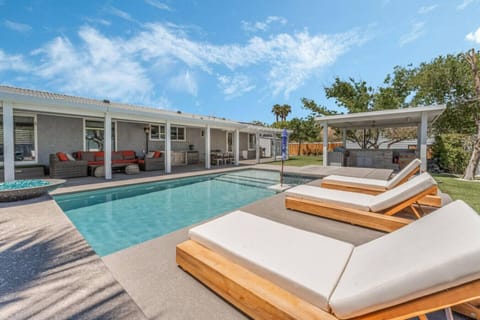 Elegant outdoor retreat featuring a pool, lounging area, and oversized covered patio.