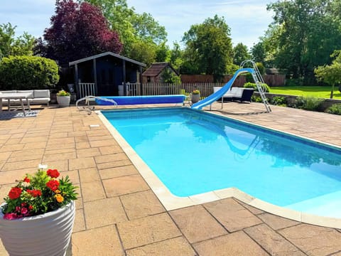 Enjoy summer by the private pool, complete with a fun slide. The massive patio features plenty of outdoor furniture, making it the perfect countryside escape for al fresco dining, sunbathing, and total relaxation.