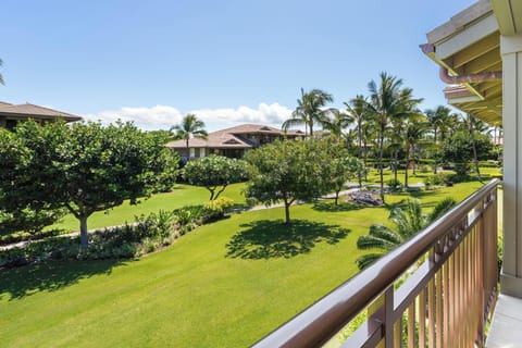Expansive tropical landscaping with manicured lawns, palm trees, and resort buildings under clear skies.