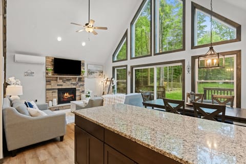 Spacious open-concept living room with soaring A-frame ceilings and floor-to-ceiling windows