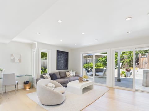 A stunning perspective showing how the living area flows naturally into the rest of the home. The beautiful hardwood floors and recessed lighting tie everything together perfectly.