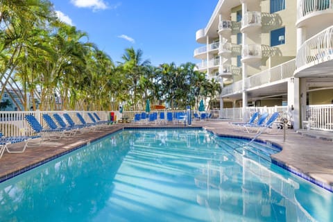 Dive into a refreshing oasis, where palm trees sway gently beside the inviting pool.