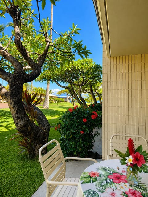 Relax on the private ground-floor lanai where vibrant tropical blooms meet manicured resort lawns, offering a serene space to unwind.