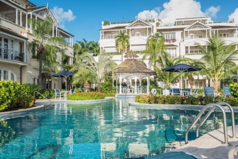 Beautiful communal pool area with sun loungers and access to the beach.