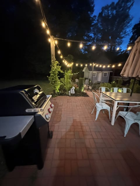 Outdoor Patio with a grill, seating area and string lights.