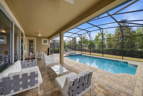 Step outside to your private oasis where sunlight glimmers on the cool blue pool. The spacious screened patio, with its modern white seating, invites you to relax and soak in the peaceful atmosphere.
