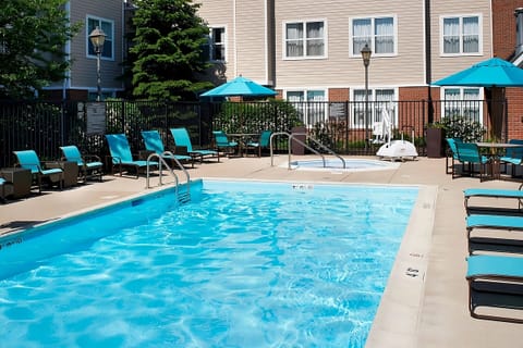 Dive into a sunlit outdoor pool with plenty of loungers.